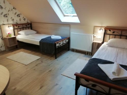 a small room with two beds and a skylight at La Mia Casa Vendégház in Kaposvár