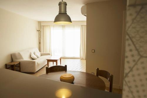 ein Wohnzimmer mit einem Tisch und einem Sofa in der Unterkunft Apartment Medes Platja in L'Estartit