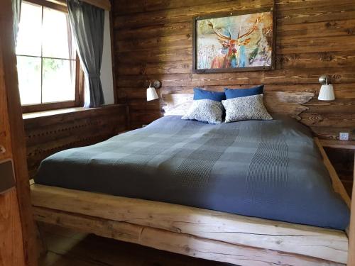 1 dormitorio con 1 cama en una cabaña de madera en Ferienwohnung Woid Mandl en Velden am Wörthersee