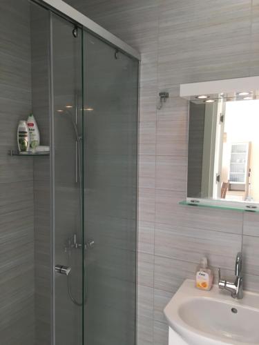 a bathroom with a glass shower and a sink at Magnolia Sea View Studio in Golden Sands