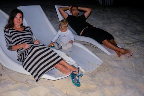 a group of people sitting in chairs on the beach at Nemo Inn in Omadhoo