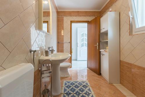 a bathroom with a sink and a toilet and a tub at Apartment Macan in Bale