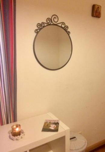 a mirror on a wall above a toilet in a bathroom at Templar Secrets House in Tomar