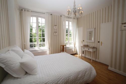 a bedroom with a white bed and two windows at Manoir Le Mesnil in Saint-Martin-aux-Chartrains