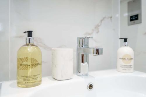 a bathroom sink with two bottles of soap on it at Tailored Stays - Central Cambridge Studios, Free Parking in Cambridge