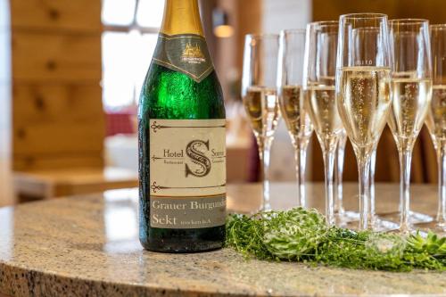 a bottle of champagne sitting on a table with wine glasses at Hotel Restaurant Sonne in Gengenbach