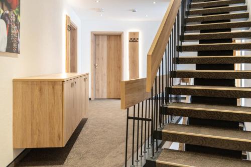 a staircase in a building with a wooden cabinet at Hotel Restaurant Sonne in Gengenbach