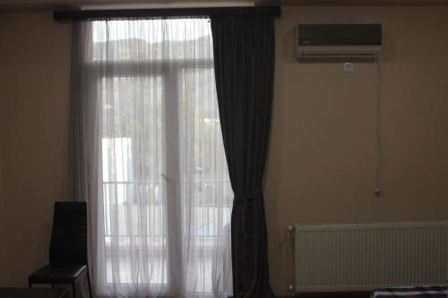 una finestra con una tenda bianca e un ventilatore di Lali's apartment a Tbilisi City