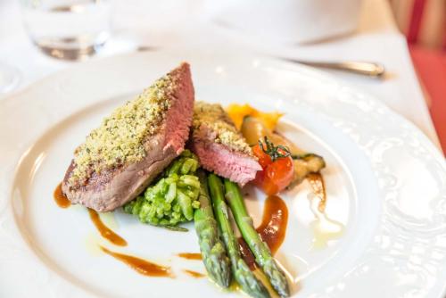 a plate of food with meat and vegetables on a table at Hotel Restaurant Sonne in Gengenbach