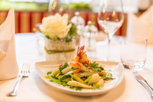 a plate of food on a table with wine glasses at Hotel Restaurant Sonne in Gengenbach