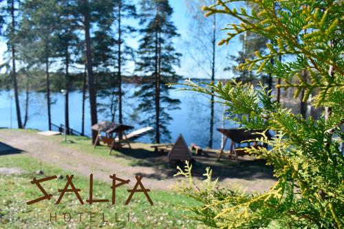 a picnic table in front of a lake at Hotelli Salpa in Luumäki