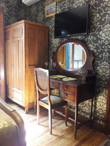 a bedroom with a desk with a mirror and a tv at Hotel City Bell in La Plata