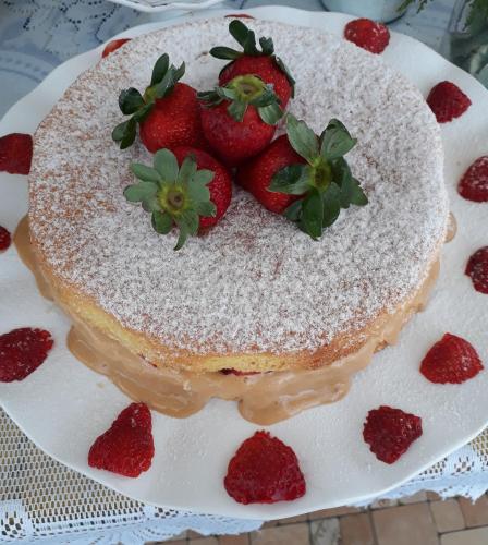 a cake with strawberries on top on a plate at Pouso dos Querubins in Tiradentes