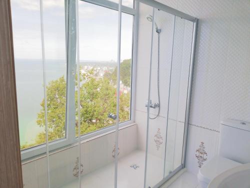 a bathroom with a shower and a window at Albatross Kvariati Guest House in Kvariati