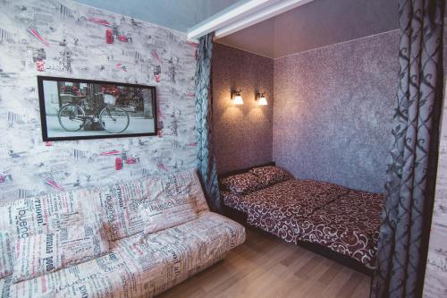Habitación con sofá y pared cubierta de graffiti. en Vip apartmen Harkovskaya, en Sumy