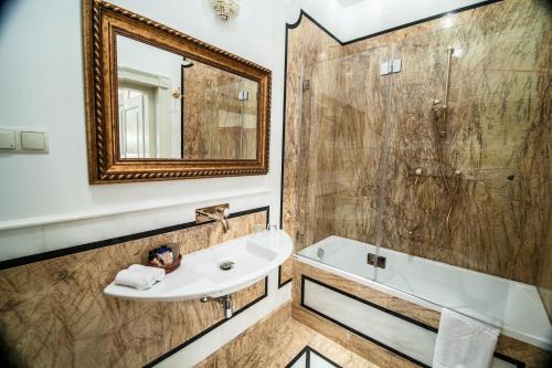 a bathroom with a sink and a tub and a mirror at Willa Różana in Nałęczów