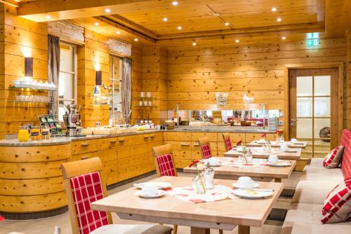 a restaurant with wooden walls and wooden tables and chairs at Hotel Restaurant Sonne in Gengenbach