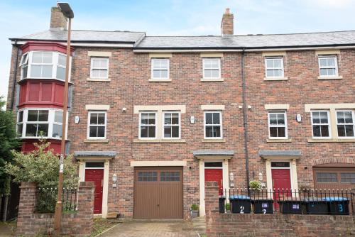 a large brick building with red doors and a gate at Dalton Crescent in Durham