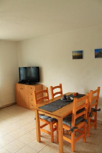 a dining room with a table and chairs and a tv at Ferienwohnung Kraft in Untersteinbach