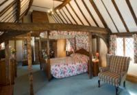 a bedroom with a bed and a chair in a room at Swan Hotel in Harleston