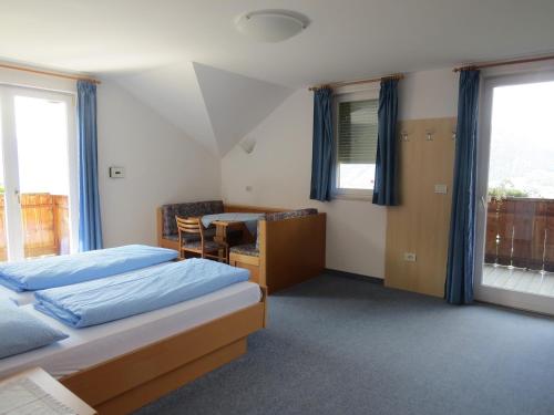 a bedroom with a bed and a desk and window at Mühlhaus in Schenna