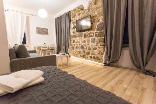 a bedroom with a bed and a stone wall at Apartment Stara vrata in Rijeka