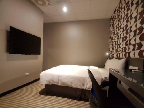 a bedroom with a bed and a flat screen tv at 住吉 Sumiyoshi 20-1 in Taipei