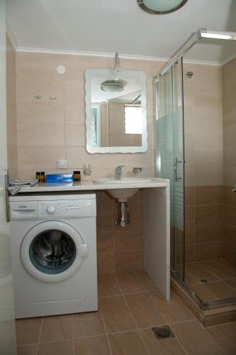 a bathroom with a washing machine and a sink at Mirtini Apartments in Myrtos