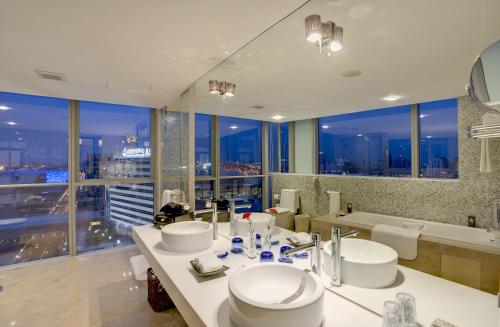 baño con 2 lavabos y bañera con vistas en China National Convention Center Grand Hotel, en Beijing