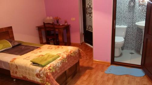 een slaapkamer met een bed, een toilet en een spiegel bij Guest House Panda in Koetaisi