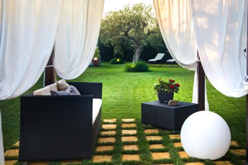カステルヴェトラーノにあるDimora La Graziaの白いカーテンと芝生のソファが備わる部屋