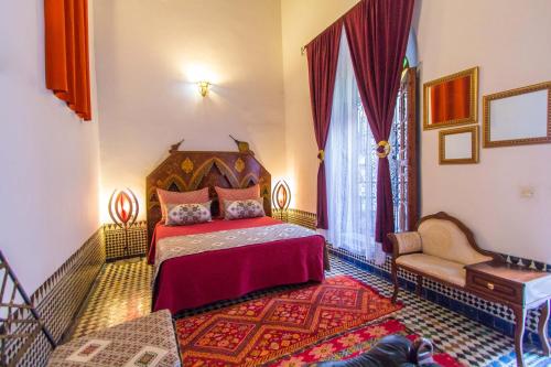 a bedroom with a bed and a couch at Riad Dar Skalli & SPA in Fès