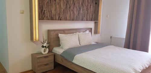 a bedroom with a bed with a wooden headboard at Nice apartment in Niš