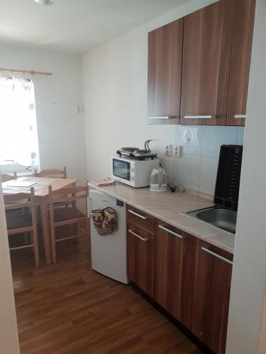 a small kitchen with a microwave and a table at Ubytování U Františka in Valašské Klobouky
