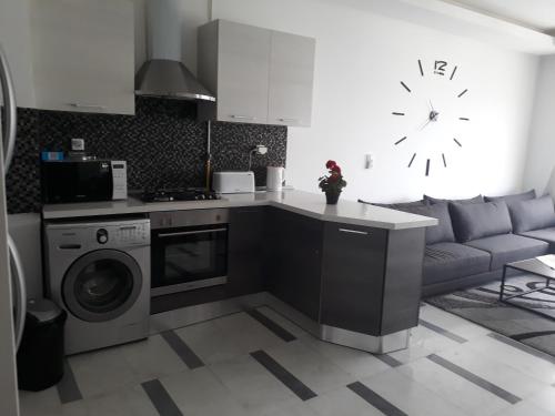 a kitchen with a washing machine and a couch at Harmony Appartement 12 in Tunis