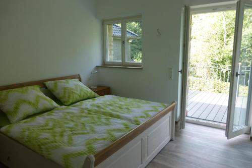 a bedroom with a bed and a sliding glass door at Ferienwohnung am Grölisbach in Roetgen