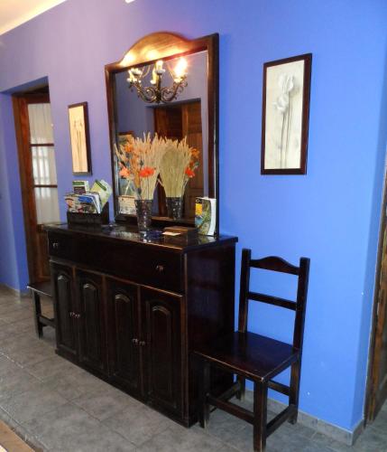 a room with a dresser and a mirror and a chair at Casa El Campu in Infiesto