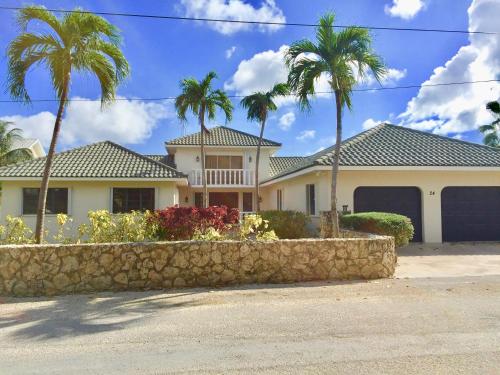 
a house that has a tree in front of it at Addison Lee Cayman Villa in George Town
