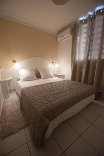 a bedroom with a large bed and a window at Locastudio - Carambole in Sainte-Anne