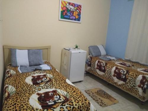 2 camas en una habitación con estampado de leopardo en Hospedagem Vovó Gina, en Aracaju