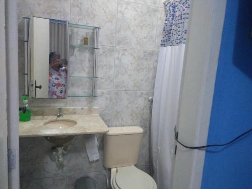 a woman taking a picture of a bathroom at Hospedagem Vovó Gina in Aracaju