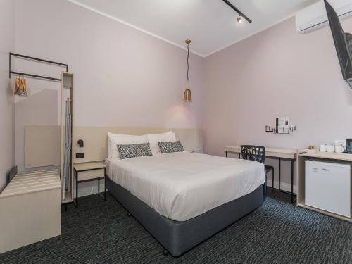 a bedroom with a bed and a desk and a kitchen at Nightcap at Belgian Beer Cafe in Perth