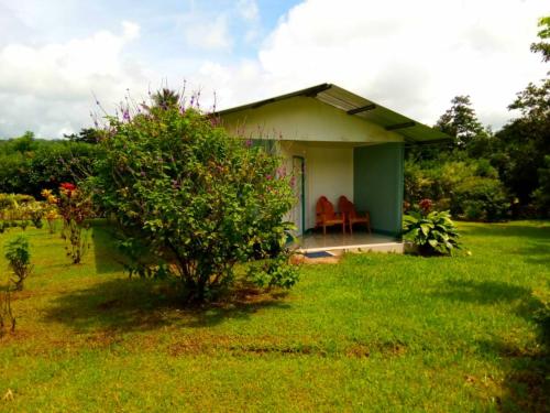 a small house with two chairs in a yard at Nacientes Lodge in Bijagua