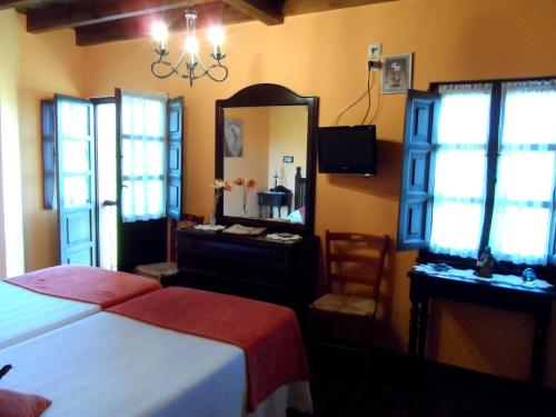 a bedroom with a bed and a mirror and a chair at Casa El Campu in Infiesto