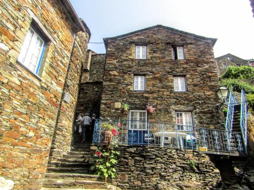an old stone building with a staircase in front of it at Casa dos Teares in Aldeia das Dez