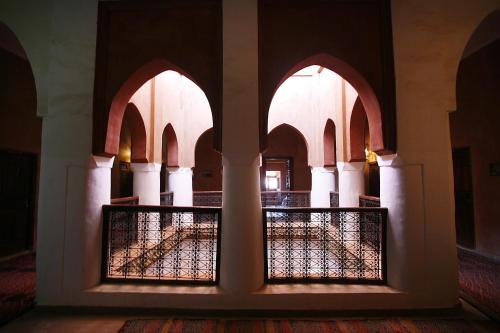 a room with arches and a fence in a building at Hotel Tomboctou in Tinerhir