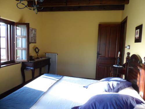 a bedroom with a large bed and a window at Casa El Campu in Infiesto