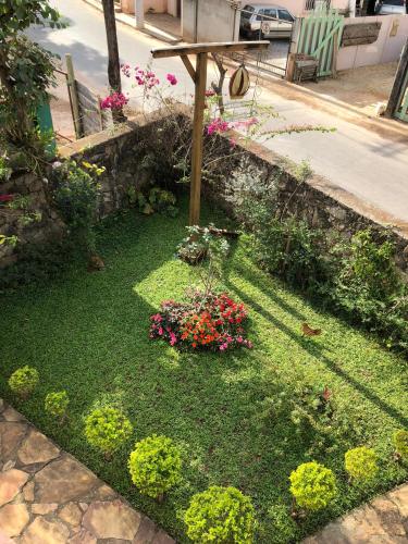 a garden with flowers and a wooden table at Pouso Realeza in Tiradentes