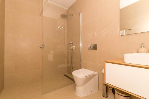 a bathroom with a shower and a toilet and a sink at Beach Condominium in Lagos