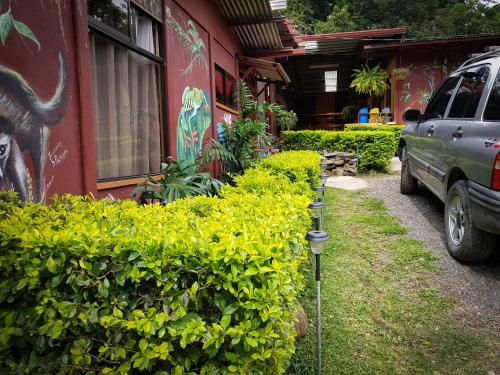 a car parked next to a building with green bushes at Greemount Hotel in Monteverde Costa Rica